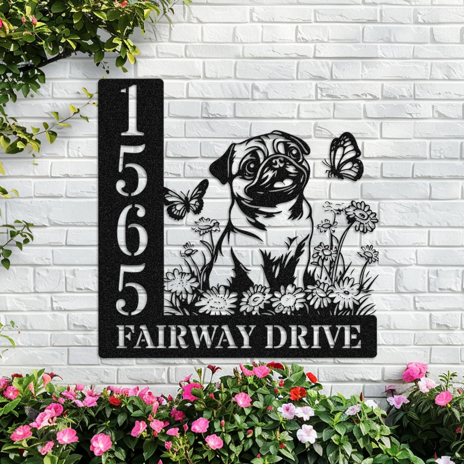 Pug-Sitting-with-Butterfly-3 Black metal address sign mounted on a white brick wall with numbers 1565 and text 'FAIRWAY DRIVE', featuring a pug sitting among flowers and butterflies, with pink flowers below