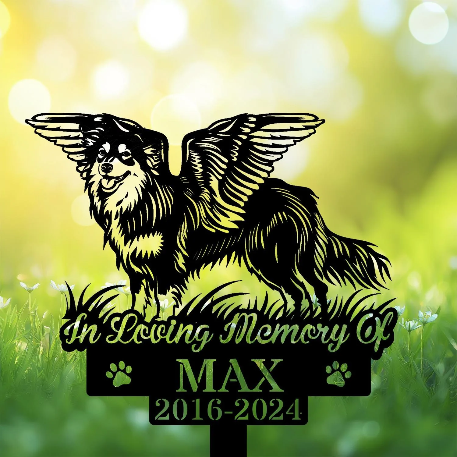 Shetland-Sheepdog-2 Black silhouette memorial sign of a winged dog standing on grass with text "In Loving Memory Of MAX 2016-2024" against a sunlit green bokeh background