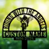 Sport-Biker-Riding-with-Angels-1 Black metal memorial sign with arched text “RIDING WITH THE ANGELS,” winged motorcyclist silhouette, customizable name and dates, shown against a sunlit grassy background