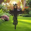 Decorative black metal memorial cross stake with heart, roses and butterflies reading "Custom Name" and years in a sunlit garden lawn