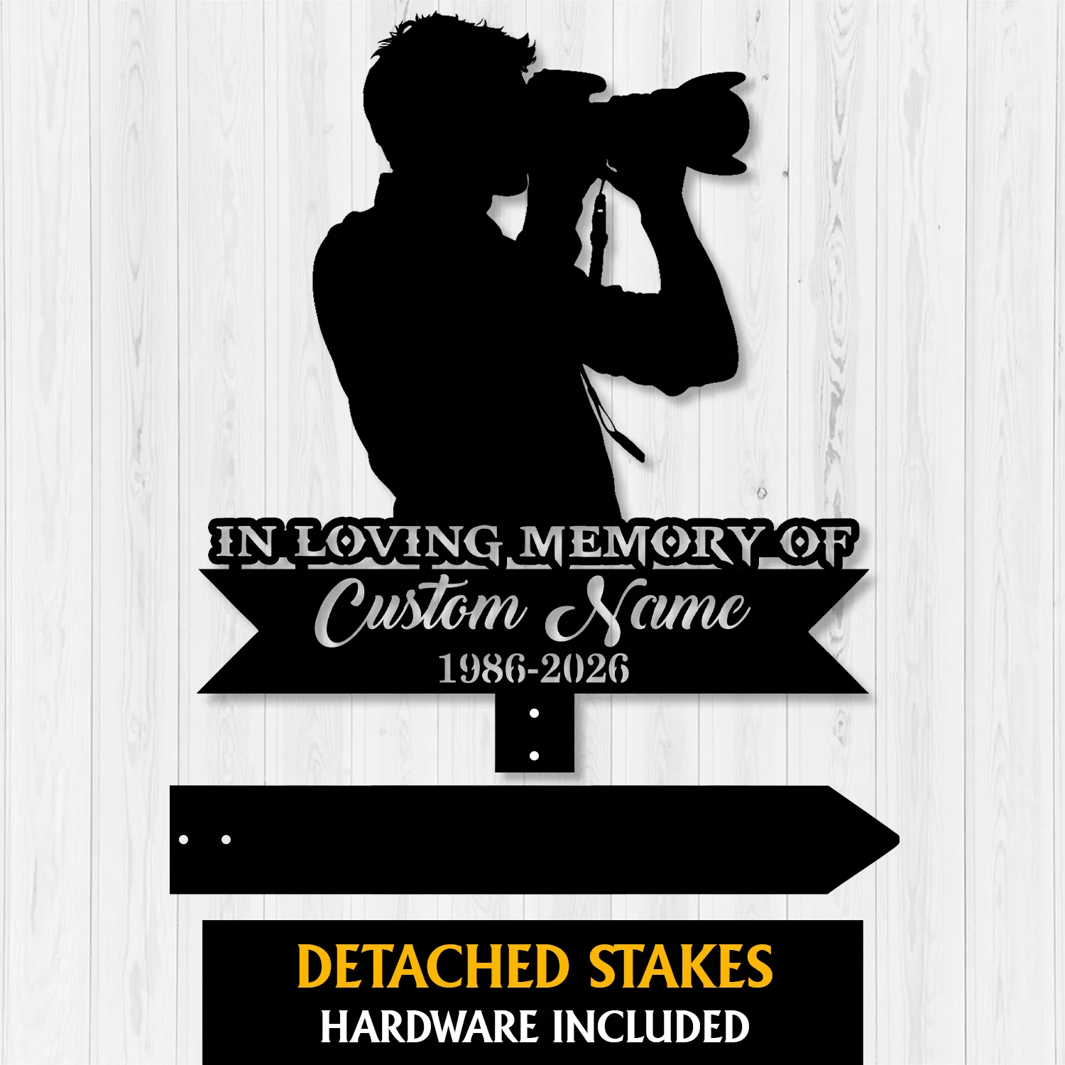Black silhouette memorial sign of a photographer holding a camera with text "In Loving Memory of" and placeholder "Custom Name 1986-2026" on a light wood background