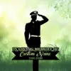 Silhouette of a saluting soldier on a memorial sign reading "In Loving Memory of Custom Name 1986-2026" against a soft green grassy background