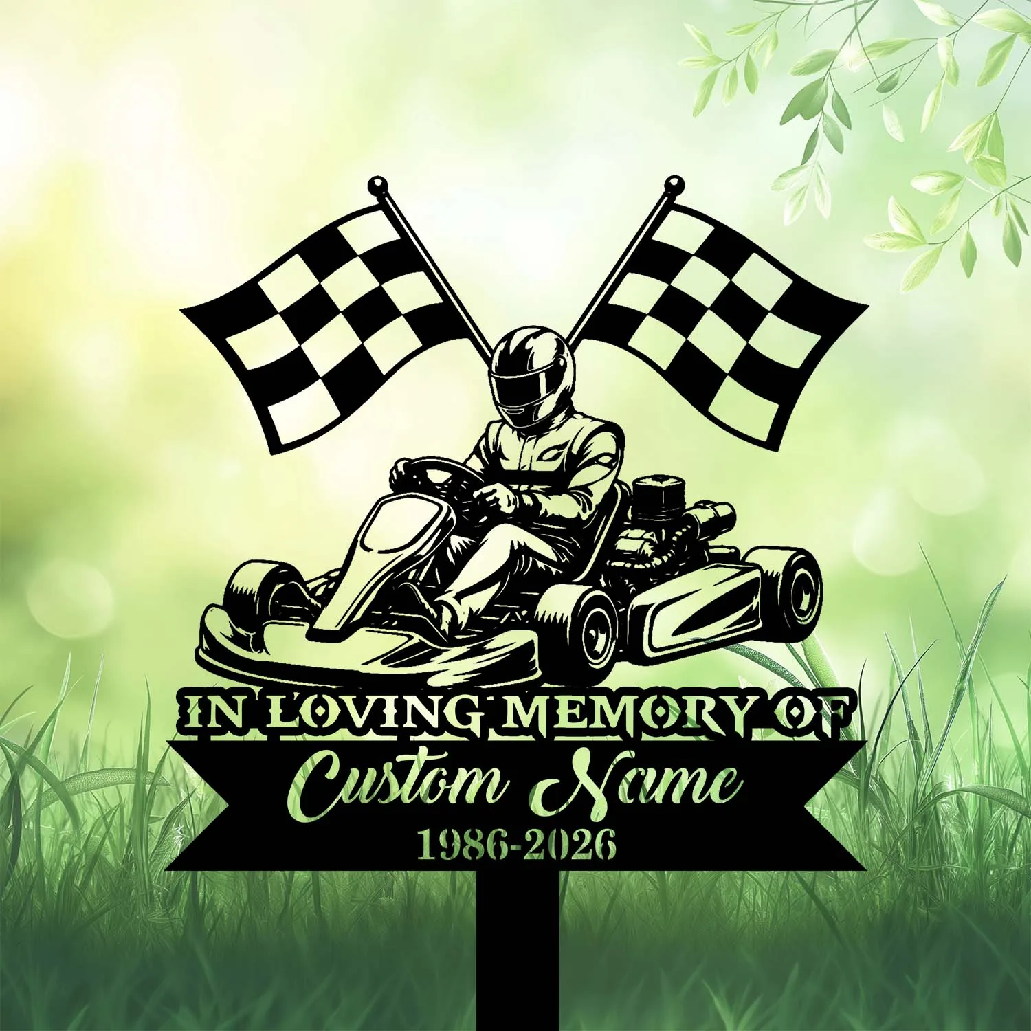 Black silhouette memorial sign of a go-kart driver with crossed checkered flags above and text reading "In Loving Memory of Custom Name 1986-2026" against a green grassy background