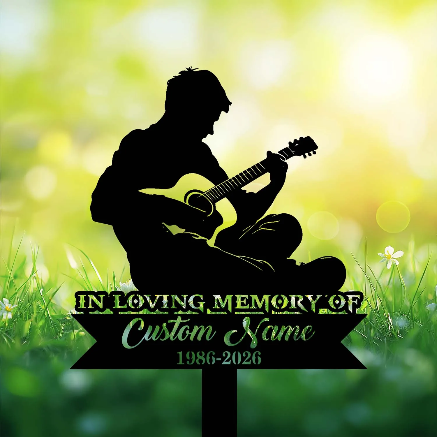 Silhouette of a seated person playing guitar above a memorial plaque reading "IN LOVING MEMORY OF Custom Name 1986-2026" against a bright grassy bokeh background