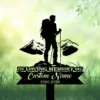 Black silhouette grave sign of a hiker with backpack and poles in front of mountains reading "In Loving Memory of Custom Name 1986-2026" on a green grassy background