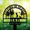 Black memorial yard sign silhouette of a golfer swinging among trees with flag, text 'Golfing in Heaven' and 'Dad 1952-2024' against a sunny green field
