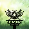 Black memorial garden sign with winged baseball glove, crossed bats, halo, the name "JASON" and years "1990-2026" against a soft green grassy background