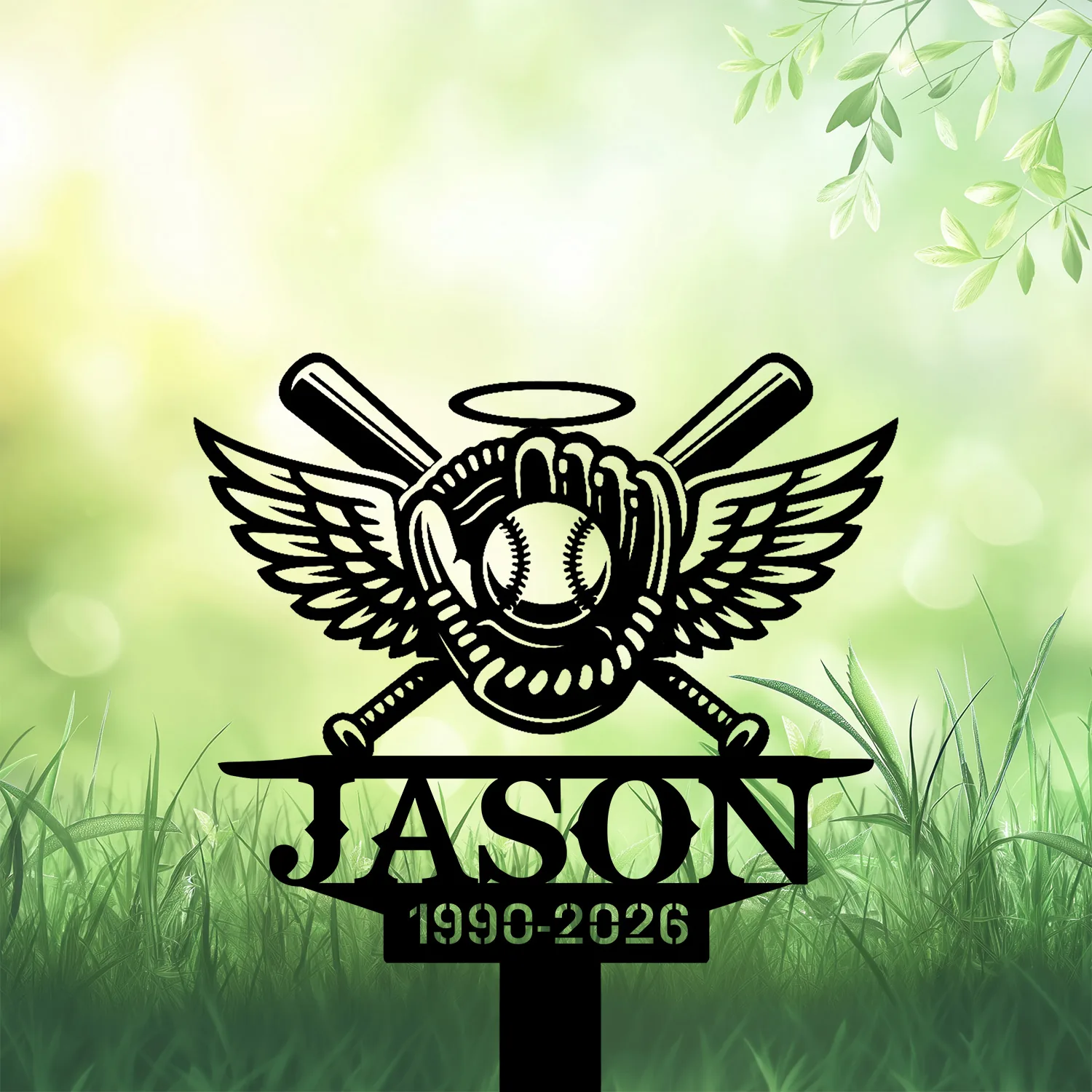 Black memorial garden sign with winged baseball glove, crossed bats, halo, the name "JASON" and years "1990-2026" against a soft green grassy background
