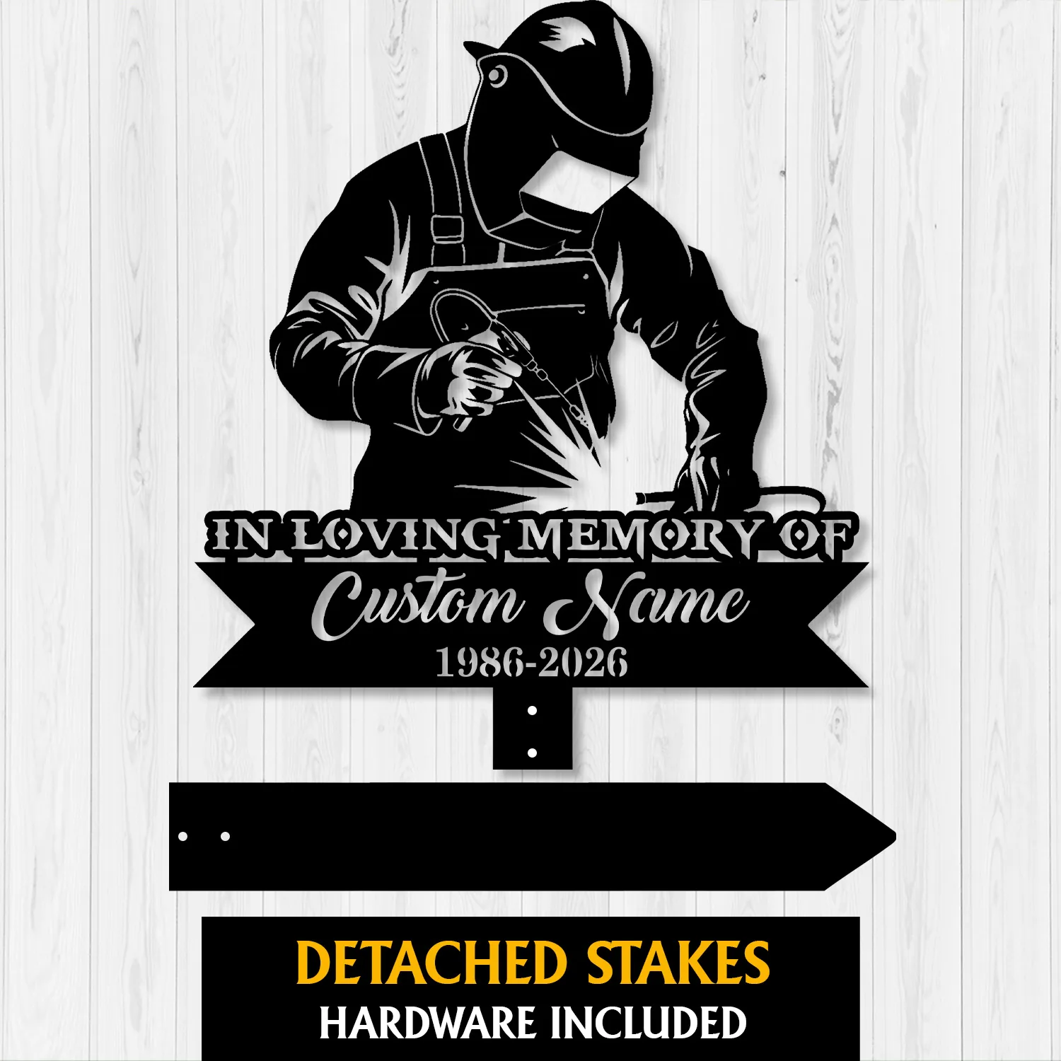 Black metal memorial yard sign showing a welder in helmet and apron with sparks, text 'IN LOVING MEMORY OF', 'Custom Name' and years '1986-2026' on a white wood background