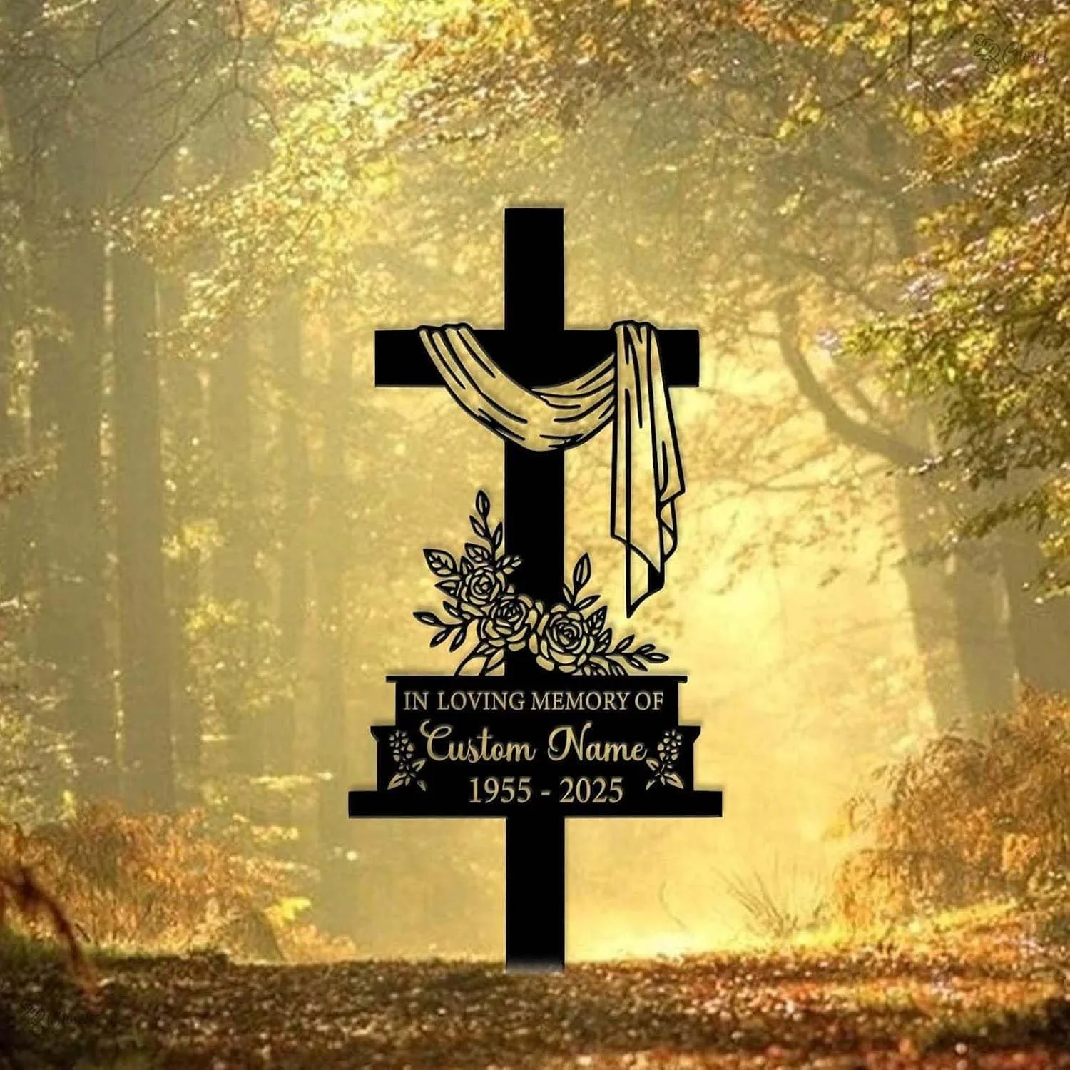 Black memorial cross with draped cloth, floral decoration and plaque reading “In Loving Memory of Custom Name 1955 - 2025” against a sunlit forest path background