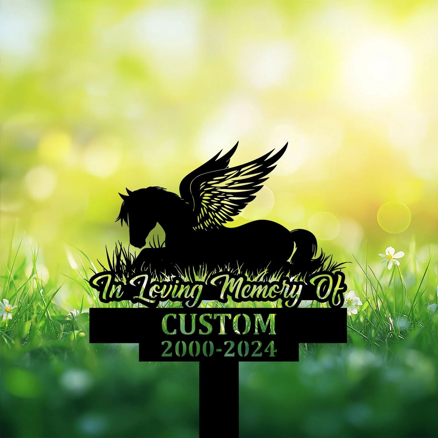 Silhouette memorial sign of a winged horse lying in grass reading "In Loving Memory Of" with customizable name and dates 2000-2024 against a bright green bokeh background