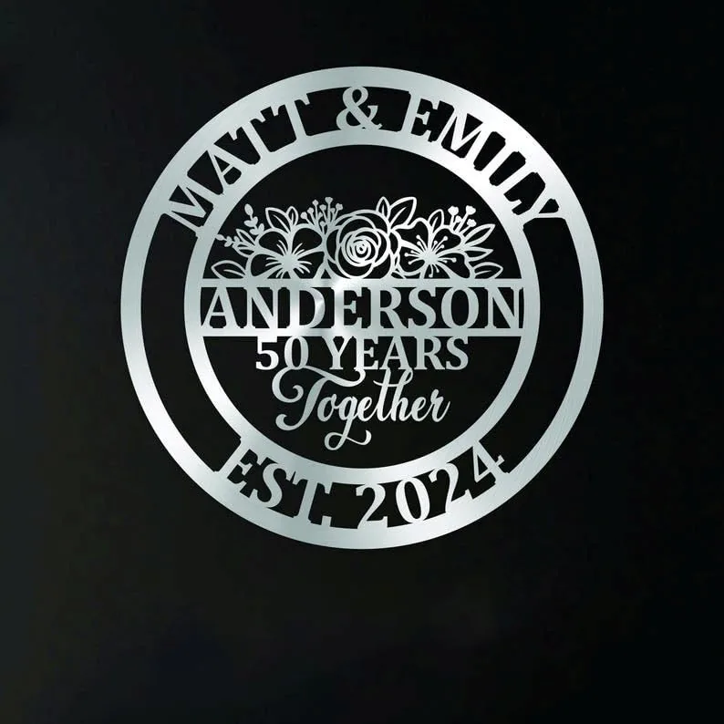 Silver circular metal sign reading 'Matt & Emily' at top, 'Anderson' center, '50 Years Together' in decorative script, 'EST 2024' at bottom on a dark background