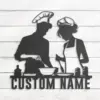 Black metal silhouette of a man and woman chefs cooking together over bowls and utensils with placeholder text "CUSTOM NAME" on a white shiplap wall
