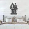 Metal wall art of a firefighter and nurse standing arm in arm above a customizable name plaque, mounted above a bed in a neutral farmhouse-style bedroom.