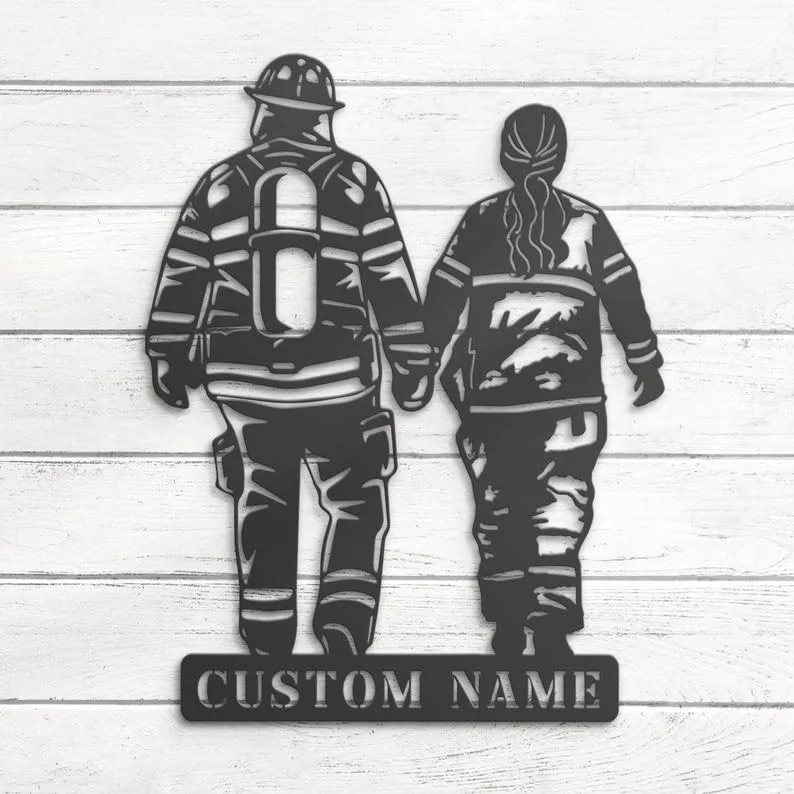 Metal wall art of two firefighters holding hands walking away, cutout design with plate reading "CUSTOM NAME", on white wood background