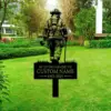 style-13.-Firefighter-Memorial-3 Garden lawn memorial sign showing a silhouetted firefighter with axe and text placeholder “IN LOVING MEMORY OF CUSTOM NAME 1955-2025” in front of green shrubs and trees