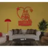 Living room with beige sofa and red wall art reading ‘Mara & David 2022’ inside a heart, yellow wall, red floor lamp and potted plant