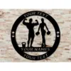 Black metal circular sign on a light brick wall showing male and female fitness silhouettes with kettlebell and dumbbells, placeholder text reading YOUR TEXT and YOUR NAMES