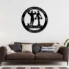 Black circular metal wall sign reading 'Training Together Denis & Emily Since 2020' with silhouettes of a man and woman holding weights, hung above a brown sofa in a modern living room