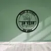 Black circular metal wall sign reading 'Mary & James' with linked pinky hands, '30 Year together' and 'Est 1994' mounted on a mint green wall over light wood floor