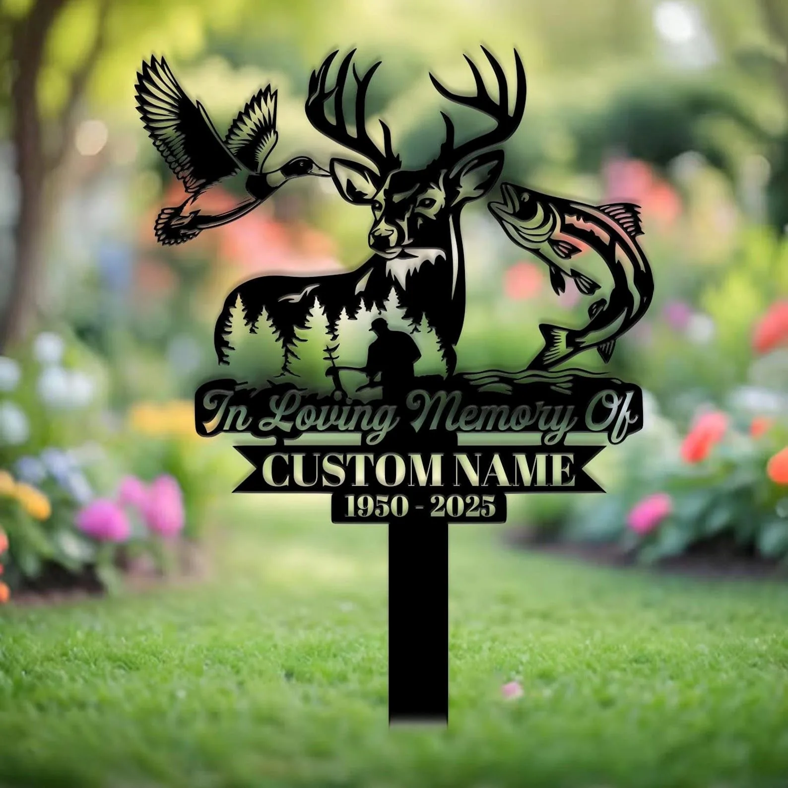 Black memorial garden stake with deer head, flying duck and leaping fish silhouettes, text reading "In Loving Memory Of" and placeholder "CUSTOM NAME 1950 - 2025" against a blurred floral lawn background