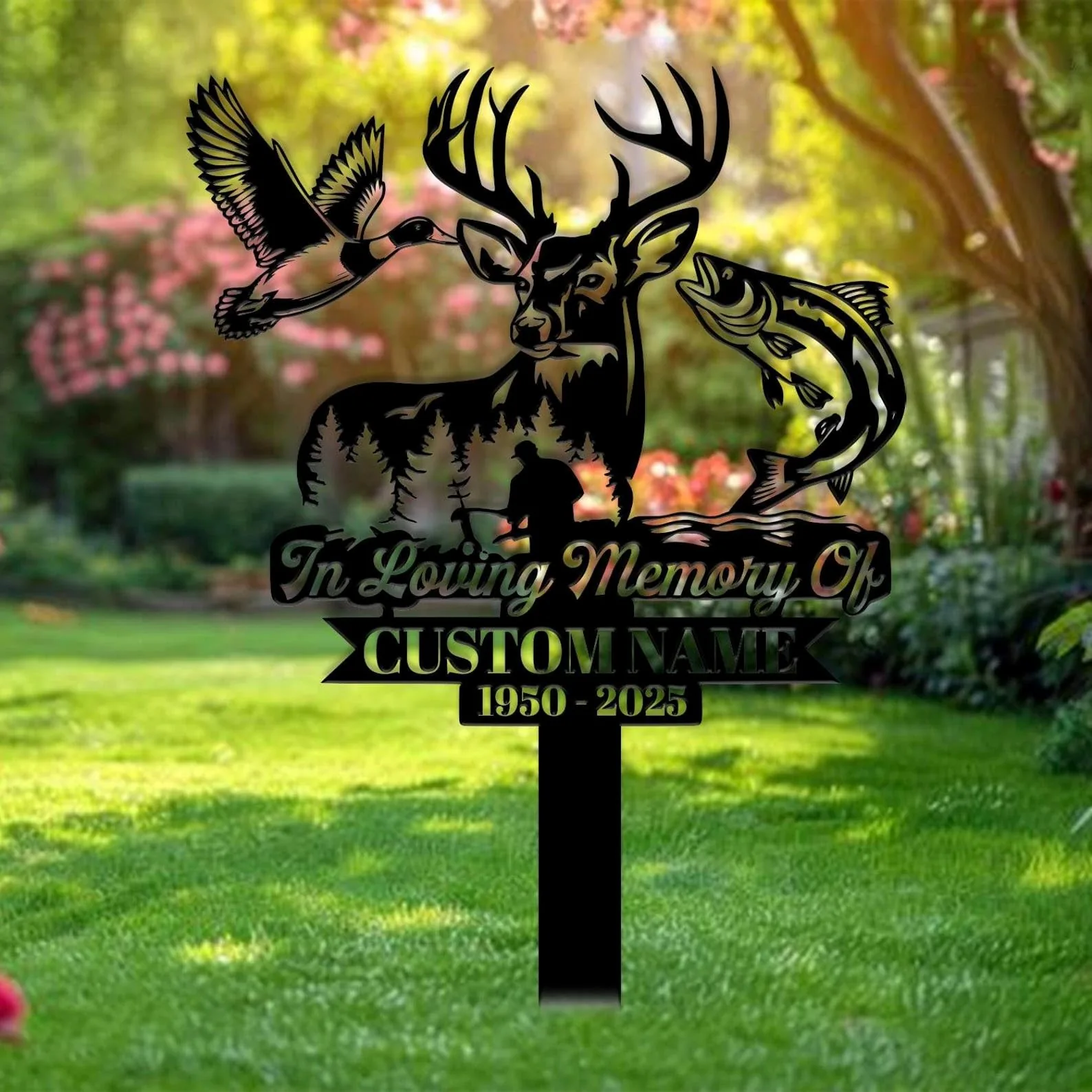 Black metal memorial yard sign with deer head silhouette, flying duck and jumping fish, text reading "In Loving Memory Of" and placeholder "CUSTOM NAME 1950 - 2025", staked in a sunlit garden lawn