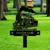 style-18.-Train-Memorial-1 Black metal memorial yard sign with a steam locomotive silhouette, text reading "In Loving Memory Of" and placeholder "CUSTOM NAME 1968-2025" staked in a green park lawn