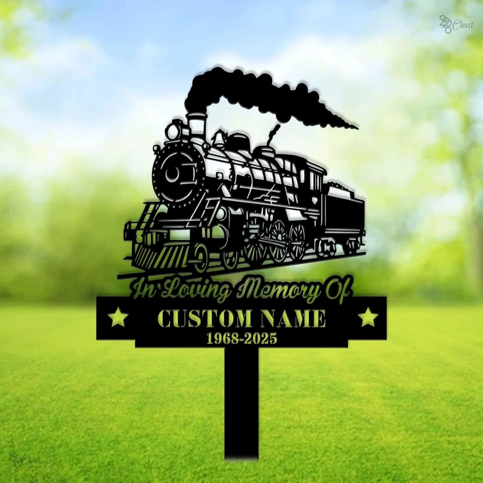 style-18.-Train-Memorial-2 Black metal memorial yard sign shaped like a steam locomotive with smoke, text 'In Loving Memory Of' and placeholder 'CUSTOM NAME 1968-2025' on green lawn background