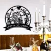Black wall decal of two embracing skeletons surrounded by roses and branches with a banner reading "David ♥ Linda" above a dining table with candles and glassware