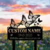 Black memorial sign with cutout butterflies and text placeholder "CUSTOM NAME" and dates "1945-2025" set against a sunset sky over a wildflower field