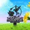 Black metal memorial stake sign reading "In Loving Memory Of" with placeholder "CUSTOM NAME" and dates 1950-2023, hummingbird and flower design on a grassy background