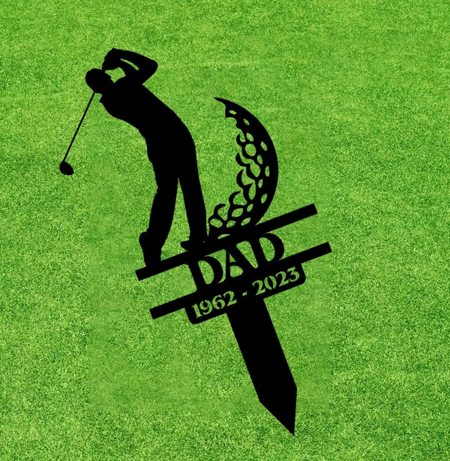Black silhouette grave marker of a golfer with the word DAD and dates 1962-2023 on green grass background