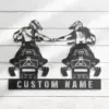Black metal wall art of two snowmobile riders fist-bumping above a rectangular plate reading 'CUSTOM NAME', mounted on white wooden planks