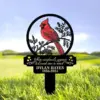 Memorial yard stake with a red cardinal illustration and text "When cardinals appear a Loved one is near" and name "Dylan Hayes 1956-2024" placed in grass
