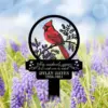 Garden memorial stake with a red cardinal illustration and text “When cardinals appear a loved one is near” above a name and dates, placed among purple flowers