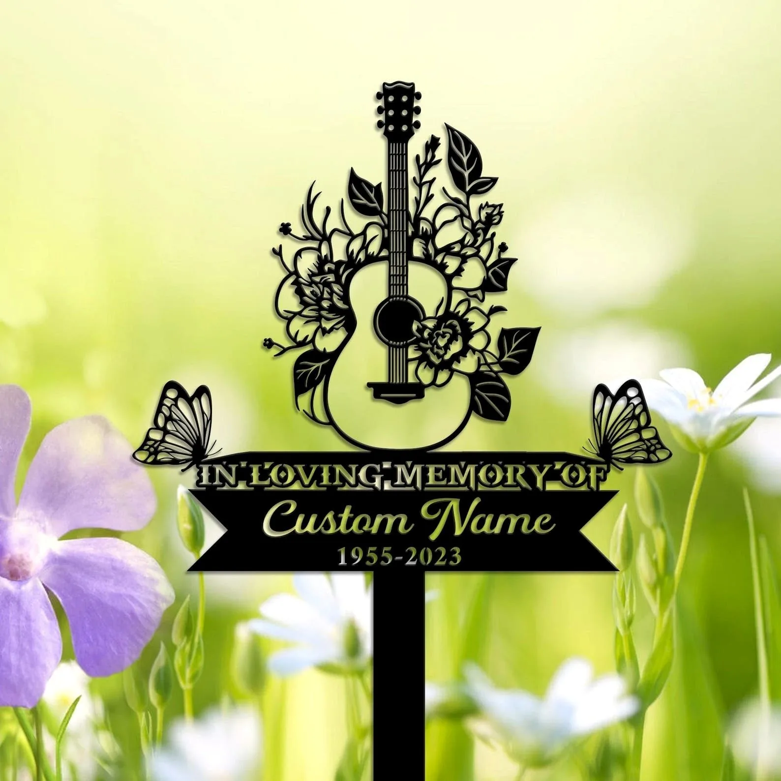 Black silhouette memorial sign with a floral acoustic guitar and butterflies over banner reading "In Loving Memory" and placeholder "Custom Name 1955-2023" against soft green floral background