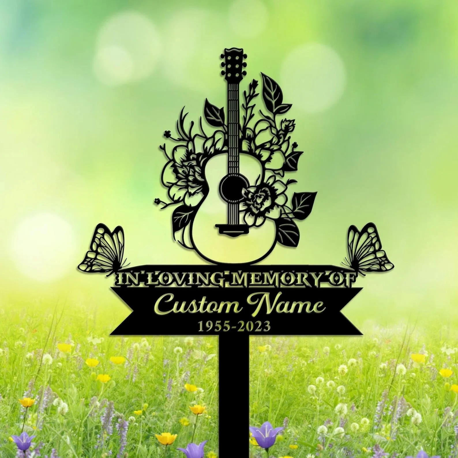 Black silhouette memorial sign with an acoustic guitar wrapped in flowers, butterflies, text reading "In Loving Memory of" and placeholder "Custom Name 1955-2023" over a green meadow background
