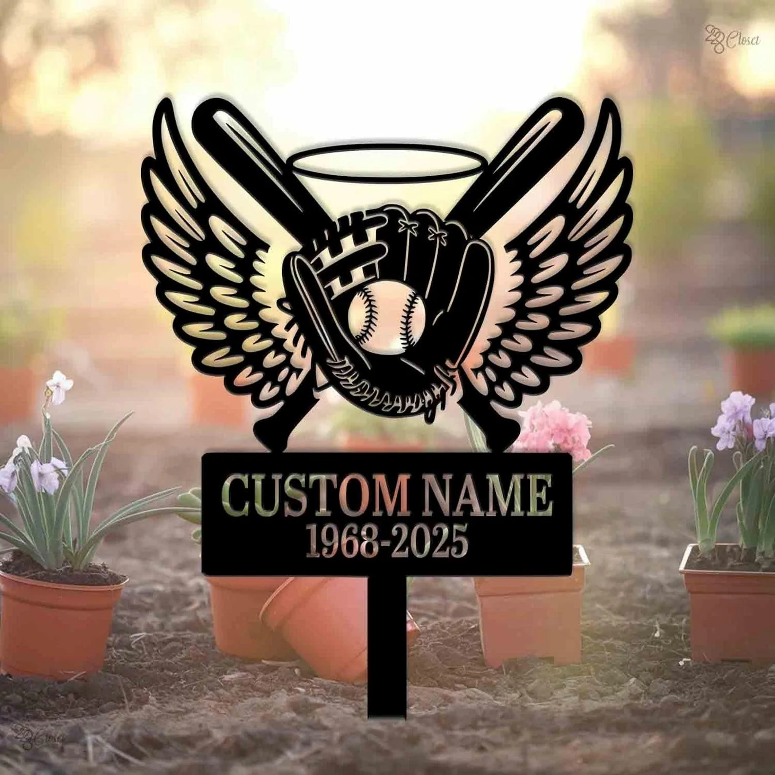 Black metal memorial sign with baseball glove holding a ball, crossed bats and wings above a customizable name and dates, pictured outdoors among potted flowers