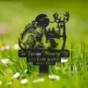 Black metal memorial garden stake with fish and deer silhouettes, pine trees, text "In Loving Memory Of" and customizable name and dates, placed in green grassy lawn