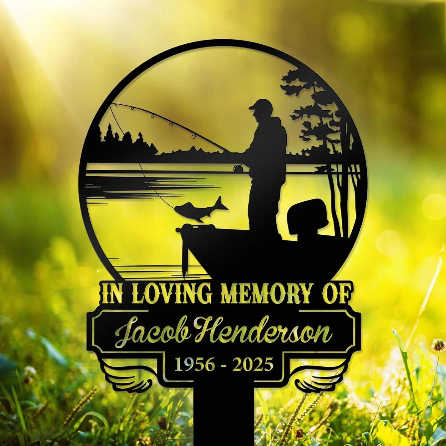 111 Black metal memorial sign showing a fisherman in a boat with a fish, text reading "In Loving Memory of Jacob Henderson 1956 - 2025" against a sunlit grassy background