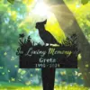 132-2 Black garden memorial stake silhouette of a cockatiel perched above flowers reading “In Loving Memory of Greta 1995 - 2024” with sunlit green trees and butterflies in background