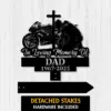Black metal memorial sign showing a motorcycle and kneeling rider with a cross, text "In Loving Memory Of DAD 1967-2025" on a light wood background