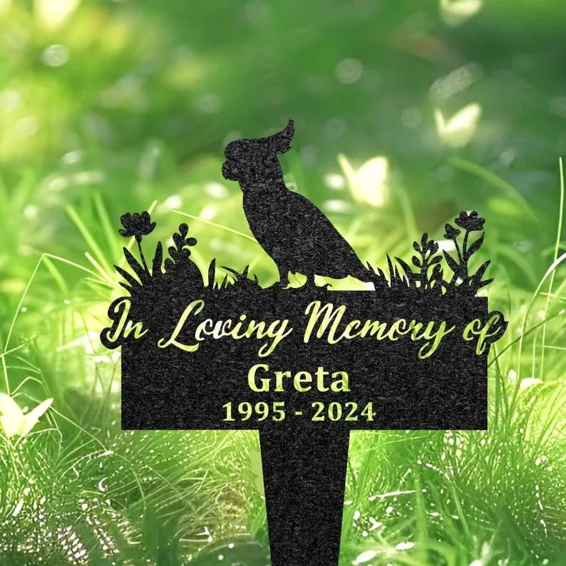 133-2 Black garden memorial stake with cockatoo silhouette and text "In Loving Memory of Greta 1995 - 2024" placed in green grassy outdoor setting