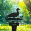 Black garden stake silhouette of a duck standing in grass with the name “Daphne” and year “2024” against a sunlit green backyard background