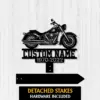 Black metal motorcycle silhouette sign with text placeholder "CUSTOM NAME" and years "1970-2022" on a white wood background, detached stakes shown