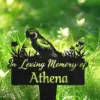 Black memorial garden stake with a parrot silhouette and floral accents reading "In Loving Memory of Athena" placed in grassy outdoor setting