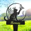Black garden stake silhouette of a winged cat with halo reaching for a butterfly above the word "Harmony" set in grassy backyard with sunlight
