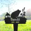 Black metal garden memorial stake shaped with a hedgehog, mushrooms and flowers engraved with name "Bandit" and dates "2021 - 2024" placed in sunlit grass