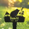 Black garden memorial stake silhouette of a hedgehog among mushrooms and flowers with name 'Bandit' and dates '2021 - 2024' placed in sunlit grassy lawn