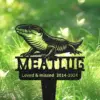 Black metal garden memorial stake showing a lizard above the name "MEATLOAF" with inscription "Loved & missed 2014-2024" stuck in green grass